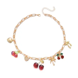 Gold holiday style necklace featuring cherry, heart, and palm tree charms.