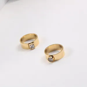 Macro view of clear square and round cut zircons set on minimalist gold jewelry bands.