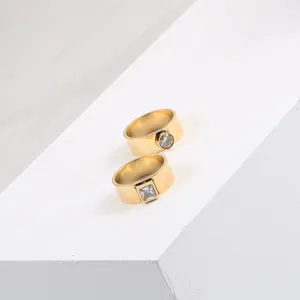 Detailed view of gold-plated titanium steel rings with square and round zircon stones.