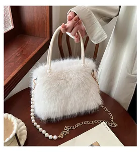 Close-up of a white fluffy handbag featuring elegant pearl and gold chain strap