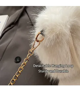 Close-up detail showing the gold-tone detachable chain clasp on a white plush handbag