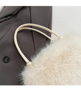 Close-up of the elegant pearl handles and soft faux fur texture of this beige handbag.