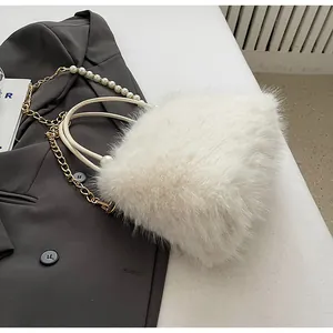 Close-up of white faux fur handbag with elegant pearl and gold chain strap detail.