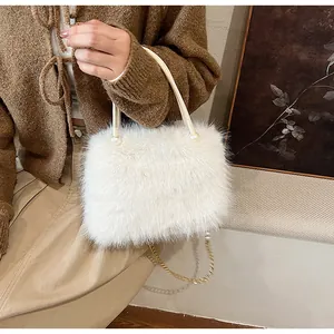 Close-up of fluffy white faux fur handbag with elegant gold chain strap