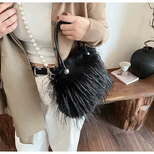 Detailed close-up of a black faux fur handbag featuring a pearl chain strap and handles