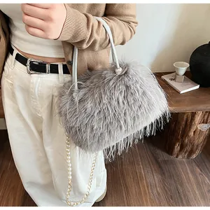 Detailed view of a grey fuzzy handbag featuring an elegant pearl chain and soft plush texture