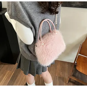 Chic pink faux fur handbag with pearl chain strap worn as a stylish crossbody bag