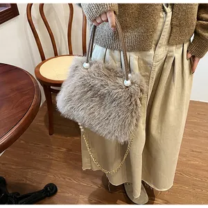 Detail view of brown faux fur handbag with gold chain and pearl accents