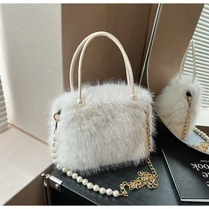 Close-up of white fluffy faux fur handbag with pearl chain and elegant double handles
