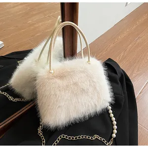 Detailed view of the soft white faux fur handbag with elegant pearl chain strap