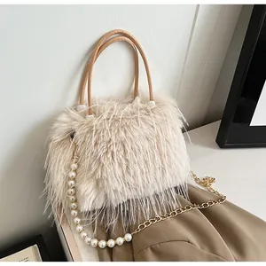 Close-up view of a cream faux fur handbag featuring elegant pearl and gold chain detail