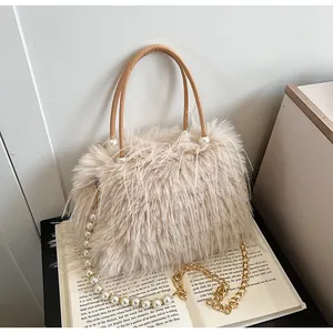 Detailed view of beige faux fur handbag with pearl chain strap and leather handle.