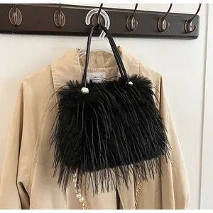 Detail view of black fluffy handbag featuring pearl accents and a gold chain strap