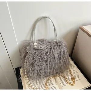 Close-up detail of grey faux fur handbag featuring elegant pearl accents and gold chain
