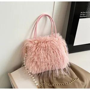 Close-up of pink faux fur handbag with elegant pearl and gold chain shoulder strap