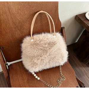 Close-up of fluffy faux fur handbag with pearl chain strap and rounded top handle.