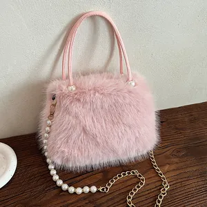 Elegant pink faux fur handbag featuring pearl handle details and a gold chain strap