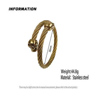 Detail view of gold twisted cable stainless steel bracelet with double skull heads