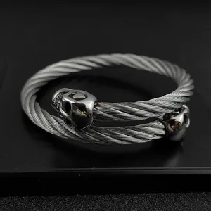 Close-up of gothic stainless steel twisted cable bracelet with dual skull charms