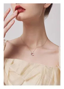 Close-up detail of minimalist silver star and moon pendant necklace with zircon stones