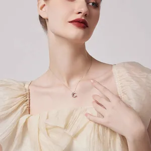 Elegant silver moon and star pendant necklace with sparkling zircon on a female model.