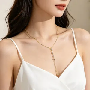 Elegant gold Y-shaped drop necklace featuring delicate pearl accents worn by a model