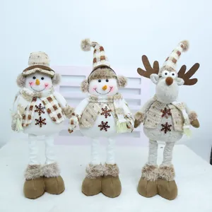 Trois poupées de Noël en peluche : deux bonhommes de neige et un renne à jambes longues.