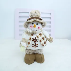 Vue détaillée d'une poupée bonhomme de neige de Noël avec bonnet et écharpe à carreaux