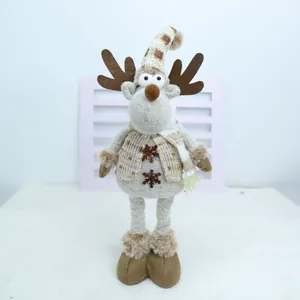 Détail d'un renne de Noël en peluche tricoté avec un bonnet et un gilet rayés