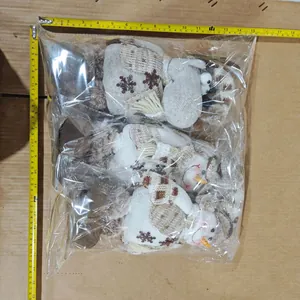 Trois poupées de Noël en tricot bonhomme de neige et renne mesurées avec un ruban