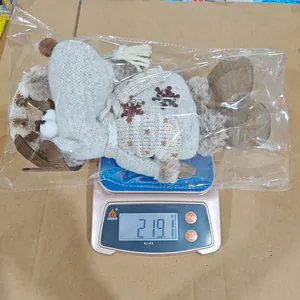 Vue détaillée de la poupée de Noël renne tricotée pesant 219,1 grammes sur une balance.