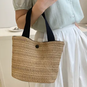 French style woven straw beach tote bag with black handles and button closure