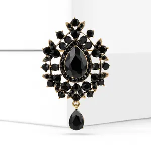 Close-up view of a vintage black crystal pendant brooch with elegant gold-tone accents