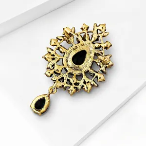 Close-up back view detail of vintage golden brooch with black glass teardrop pendant