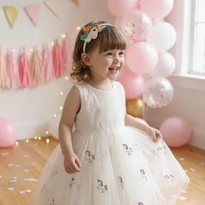 Primo piano di una bambina felice con un cerchietto ricamato a unicorno bianco a un compleanno
