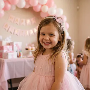 Bambina che indossa un cerchietto ricamato con fenicottero per una festa