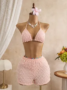 Primo piano di un set bikini rosa testurizzato con pantaloncini abbinati su un manichino da sarta