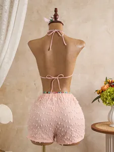 Vista posteriore del top bikini rosa con lacci e pantaloncini testurizzati con perline.