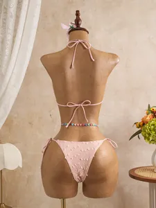 Vista posteriore di un set bikini rosa testurizzato con scollo all'americana e lacci