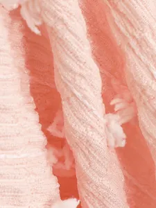 Primo piano dettagliato del tessuto bikini rosa strutturato con dettagli nappine bianche