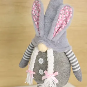 Detailed view of handmade Easter bunny gnome with pink floral ears and white braids