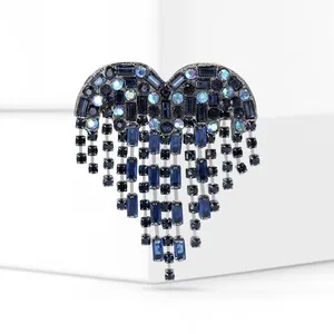 Detaillierte Nahaufnahme einer eleganten blauen Kristall-Herz-Brosche mit stilvollen Quasten.