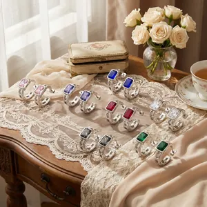 Variety of faceted rectangular zircon earrings in vibrant colors on a vintage table.