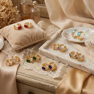 Close-up macro view of colorful rectangular cubic zirconia gold earrings details