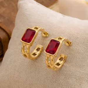 Detailed macro view of gold stainless steel hoop earrings with rectangular red zircon