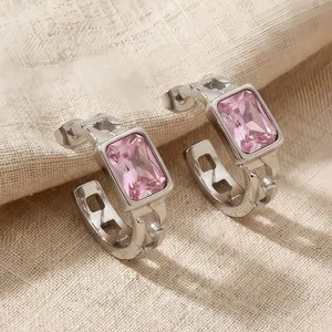 Detail of stainless steel hoop earrings with a faceted rectangular pink zircon stone.