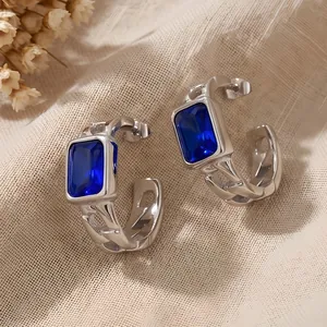 Detail view of stainless steel C-shaped earrings featuring rectangular blue zircon stones