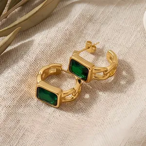 Close-up of gold-plated stainless steel earrings featuring emerald green rectangular zircon