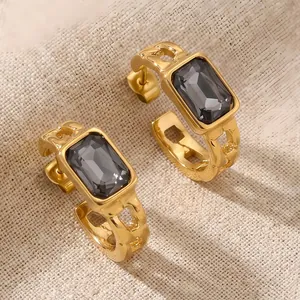 Close-up of gold-plated stainless steel earrings with rectangular dark grey zircon.