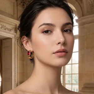 Close-up of gold stainless steel hoop earrings with rectangular red zircon on model